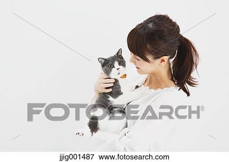 Japanese young woman in a white shirt holding cat View Large Photo Image Stock Photo - Japanese young woman in a white shirt holding cat. Fotosearch