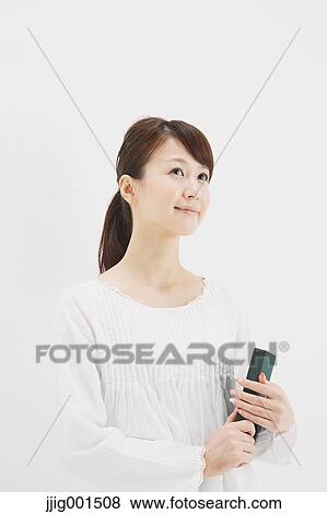 Japanese young woman in a white shirt with a book against white background View Large Photo Image Stock Photo - Japanese young woman in a white shirt with a book against white background. Fotosearch
