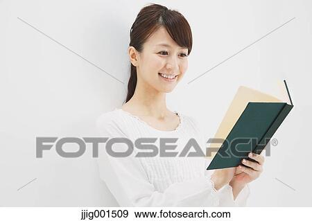 Stock Photo - Japanese young woman in a white shirt with a book against white background. Fotosearch