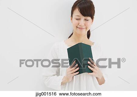 Japanese young woman in a white shirt with a book against white background View Large Photo Image Stock Photograph - Japanese young woman in a white shirt with a book against white background. Fotosearch