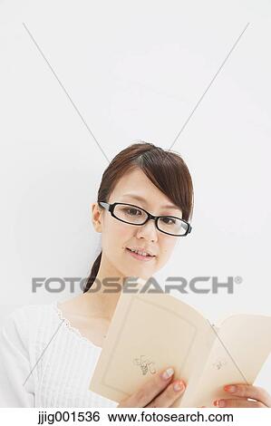 Japanese young woman in a white shirt with a book against white background View Large Photo Image Stock Photograph - Japanese young woman in a white shirt with a book against white background. Fotosearch