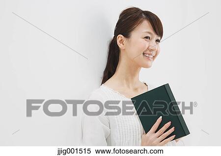 Japanese young woman in a white shirt with a book against white background View Large Photo Image Stock Photography - Japanese young woman in a white shirt with a book against white background. Fotosearch