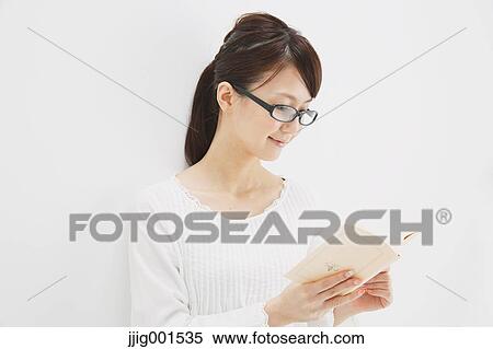Japanese young woman in a white shirt with a book against white background View Large Photo Image Stock Photography - Japanese young woman in a white shirt with a book against white background. Fotosearch
