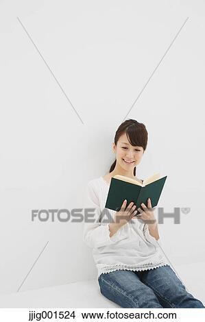 Japanese young woman in jeans and white shirt with a book against white background View Large Photo Image Picture - Japanese young woman in jeans and white shirt with a book against white background. Fotosearch