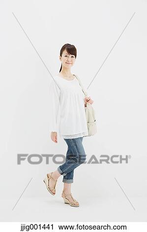 Japanese young woman in jeans and white shirt standing against white background View Large Photo Image Stock Image - Japanese young woman in jeans and white shirt standing against white background. Fotosearch