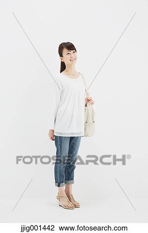 Japanese young woman in jeans and white shirt standing against white background View Large Photo Image Stock Image - Japanese young woman in jeans and white shirt standing against white background. Fotosearch