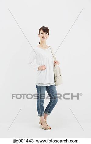 Japanese young woman in jeans and white shirt standing against white background View Large Photo Image Stock Image - Japanese young woman in jeans and white shirt standing against white background. Fotosearch