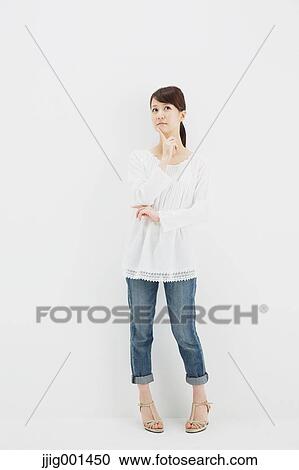 Japanese young woman in jeans and white shirt standing against white background View Large Photo Image Stock Image - Japanese young woman in jeans and white shirt standing against white background. Fotosearch