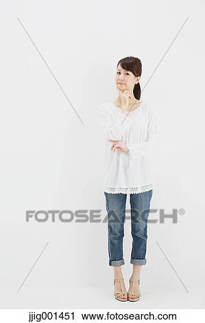 Japanese young woman in jeans and white shirt standing against white background View Large Photo Image Stock Image - Japanese young woman in jeans and white shirt standing against white background. Fotosearch