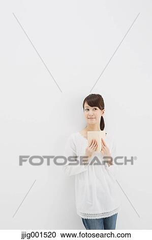 Japanese young woman in jeans and white shirt with a book against white background View Large Photo Image Stock Image - Japanese young woman in jeans and white shirt with a book against white background. Fotosearch