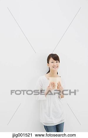 Japanese young woman in jeans and white shirt with a book against white background View Large Photo Image Stock Image - Japanese young woman in jeans and white shirt with a book against white background. Fotosearch