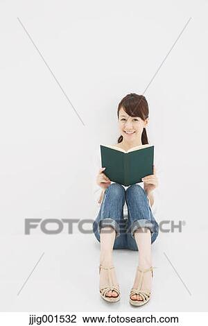 Japanese young woman in jeans and white shirt with a book against white background View Large Photo Image Stock Image - Japanese young woman in jeans and white shirt with a book against white background. Fotosearch