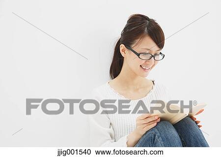 Japanese young woman in jeans and white shirt with a book against white background View Large Photo Image Stock Image - Japanese young woman in jeans and white shirt with a book against white background. Fotosearch