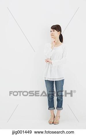 Japanese young woman in jeans and white shirt standing against white background View Large Photo Image Stock Photo - Japanese young woman in jeans and white shirt standing against white background. Fotosearch