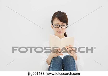 Japanese young woman in jeans and white shirt with a book against white background View Large Photo Image Stock Photo - Japanese young woman in jeans and white shirt with a book against white background. Fotosearch