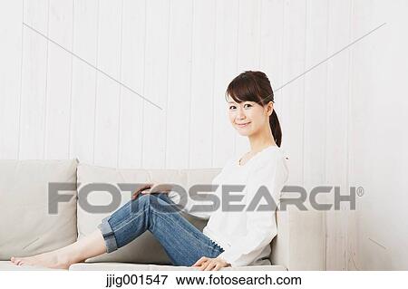 Japanese young woman in jeans and white shirt on the sofa View Large Photo Image Stock Photo - Japanese young woman in jeans and white shirt on the sofa. Fotosearch