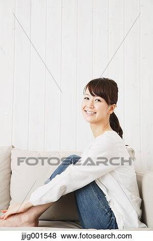 Japanese young woman in jeans and white shirt on the sofa View Large Photo Image Stock Photo - Japanese young woman in jeans and white shirt on the sofa. Fotosearch