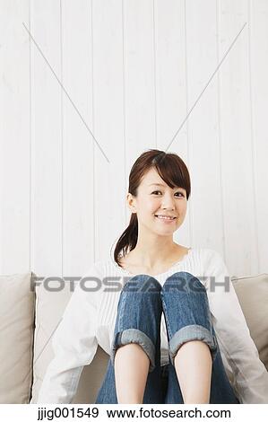 Japanese young woman in jeans and white shirt on the sofa View Large Photo Image Stock Photo - Japanese young woman in jeans and white shirt on the sofa. Fotosearch