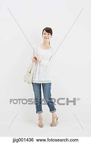Japanese young woman in jeans and white shirt standing against white background View Large Photo Image Stock Photograph - Japanese young woman in jeans and white shirt standing against white background. Fotosearch