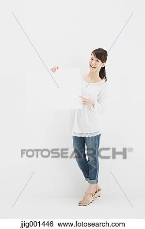 Japanese young woman in jeans and white shirt standing against white background View Large Photo Image Stock Photograph - Japanese young woman in jeans and white shirt standing against white background. Fotosearch