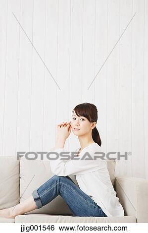 Japanese young woman in jeans and white shirt on the sofa View Large Photo Image Stock Photograph - Japanese young woman in jeans and white shirt on the sofa. Fotosearch