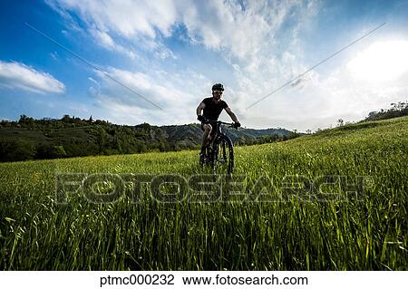 Stock Image - Man riding mountain bike in nature in the Bologna countryside, Italy. Fotosearch