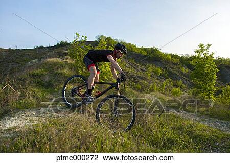 Stock Image - Man riding mountain bike in nature in the Bologna countryside, Italy. Fotosearch