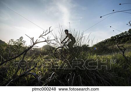 Stock Photo - Man riding mountain bike in nature in the Bologna countryside, Italy. Fotosearch