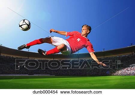 Soccer Player Kicking The Ball In Mid-Air View Large Photo Image Picture - Soccer Player Kicking The Ball In Mid-Air. Fotosearch