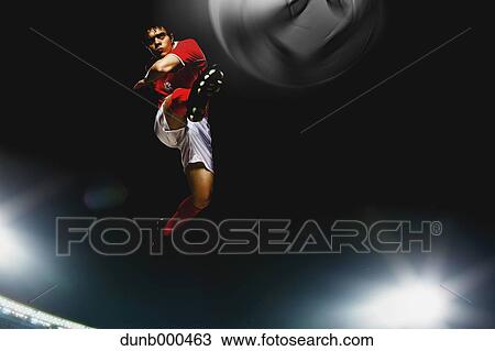 Stock Image - Soccer Player Kicking The Ball In Mid-Air. Fotosearch