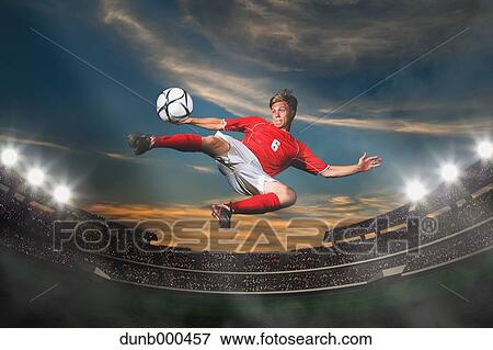 Soccer Player Kicking The Ball In Mid-Air View Large Photo Image Stock Photo - Soccer Player Kicking The Ball In Mid-Air. Fotosearch