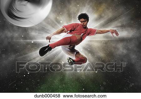 Soccer Player Kicking The Ball In Mid-Air View Large Photo Image Stock Photo - Soccer Player Kicking The Ball In Mid-Air. Fotosearch