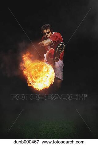 Stock Photo - Soccer Player Kicking The Ball In Mid-Air. Fotosearch