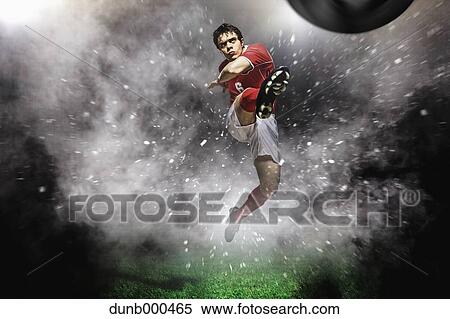 Soccer Player Kicking The Ball In Mid-Air View Large Photo Image Stock Photography - Soccer Player Kicking The Ball In Mid-Air. Fotosearch