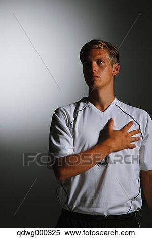 Stock Photography - Soccer Player With Hand On Chest. Fotosearch