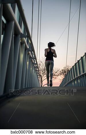 Stock Photo - Young Girl Running On A Bridge. Fotosearch