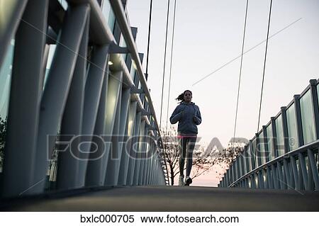 Stock Photography - Young Girl Running On A Bridge. Fotosearch