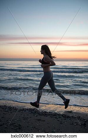 Stock Image - Young Girl Running On The Beach. Fotosearch