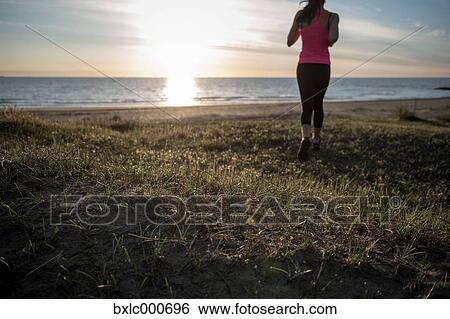 Stock Photograph - Young Girl Running On The Beach. Fotosearch