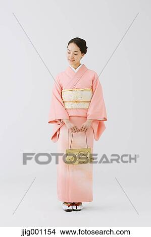 Picture - Young Japanese woman in a traditional kimono against white background. Fotosearch