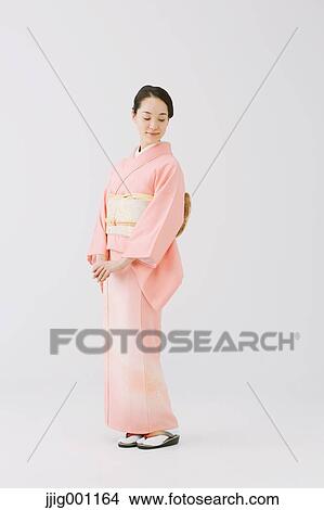 Picture - Young Japanese woman in a traditional kimono against white background. Fotosearch