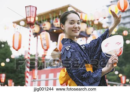 Picture - Young Japanese woman in a traditional kimono at a summer festival. Fotosearch