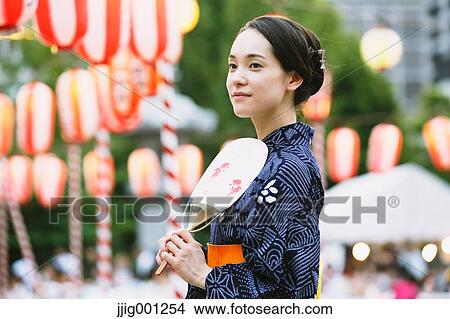 Picture - Young Japanese woman in a traditional kimono at a summer festival. Fotosearch
