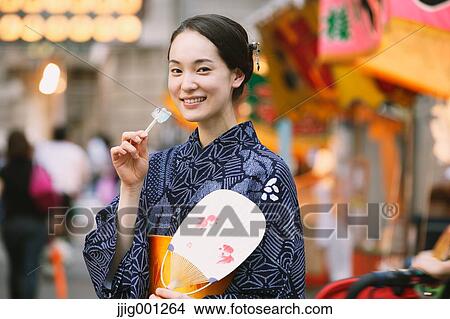 Picture - Young Japanese woman in a traditional kimono at a summer festival. Fotosearch