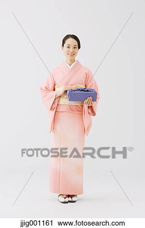 Young Japanese woman in a traditional kimono against white background View Large Photo Image Stock Image - Young Japanese woman in a traditional kimono against white background. Fotosearch
