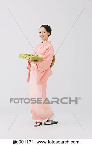 Young Japanese woman in a traditional kimono against white background View Large Photo Image Stock Image - Young Japanese woman in a traditional kimono against white background. Fotosearch