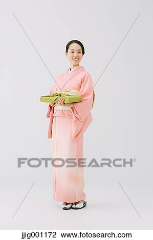 Young Japanese woman in a traditional kimono against white background View Large Photo Image Stock Image - Young Japanese woman in a traditional kimono against white background. Fotosearch