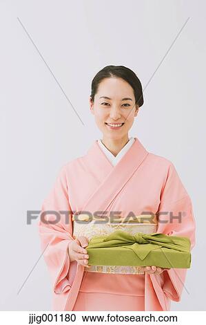 Young Japanese woman in a traditional kimono against white background View Large Photo Image Stock Image - Young Japanese woman in a traditional kimono against white background. Fotosearch