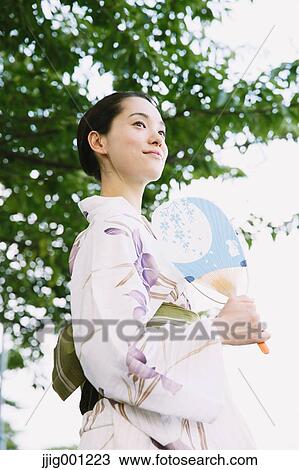 Stock Image - Young Japanese woman in a traditional kimono. Fotosearch