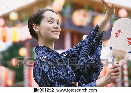 Young Japanese woman in a traditional kimono at a summer festival View Large Photo Image Stock Image - Young Japanese woman in a traditional kimono at a summer festival. Fotosearch